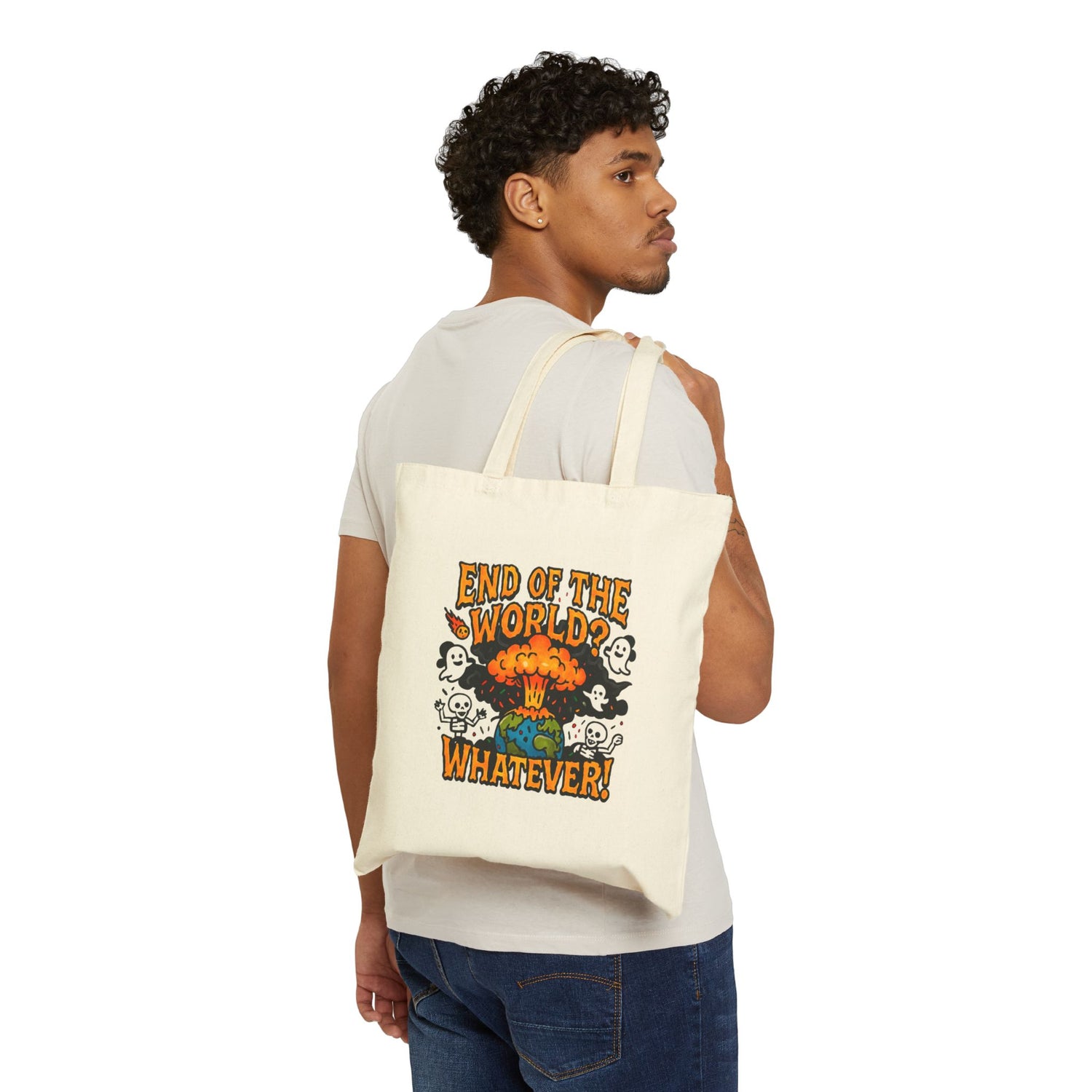 A man with dark, curly hair and dark skin stands with his back to the viewer, turning his head slightly to the right to look sideways. He is wearing a light-colored t-shirt and dark denim jeans. A light canvas tote bag is slung over his shoulder. The tote bag features a colorful graphic depicting a mushroom cloud explosion over the earth, surrounded by smoke clouds shaped like stylized ghosts and skulls. Above the graphic, the text reads 'END OF THE WORLD?', and below it, 'WHATEVER!'. The background is whit